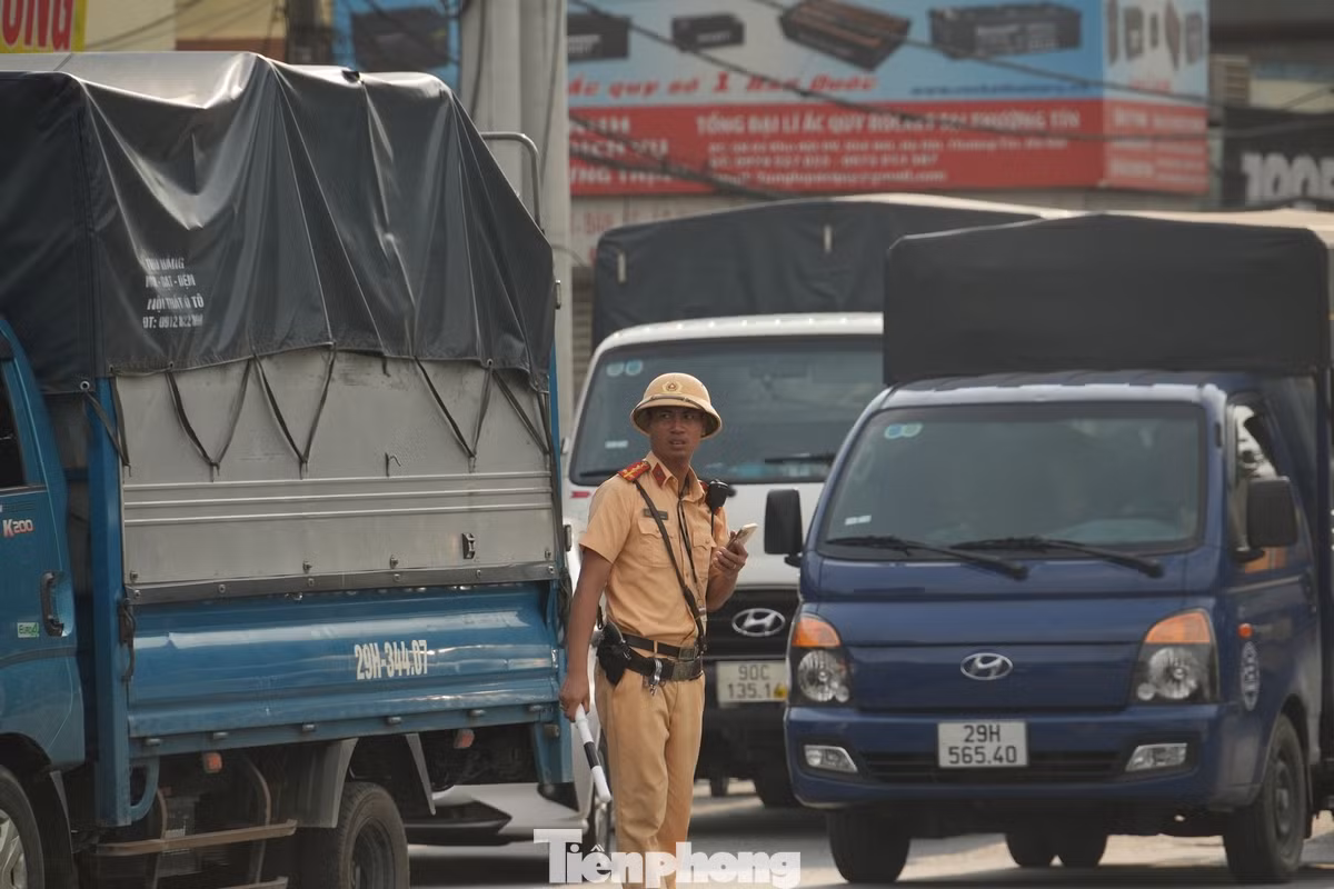 Lực lượng công an vất vả phân luồng các phương tiện đi lên cầu vượt đoạn qua thị trấn Thường Tín.