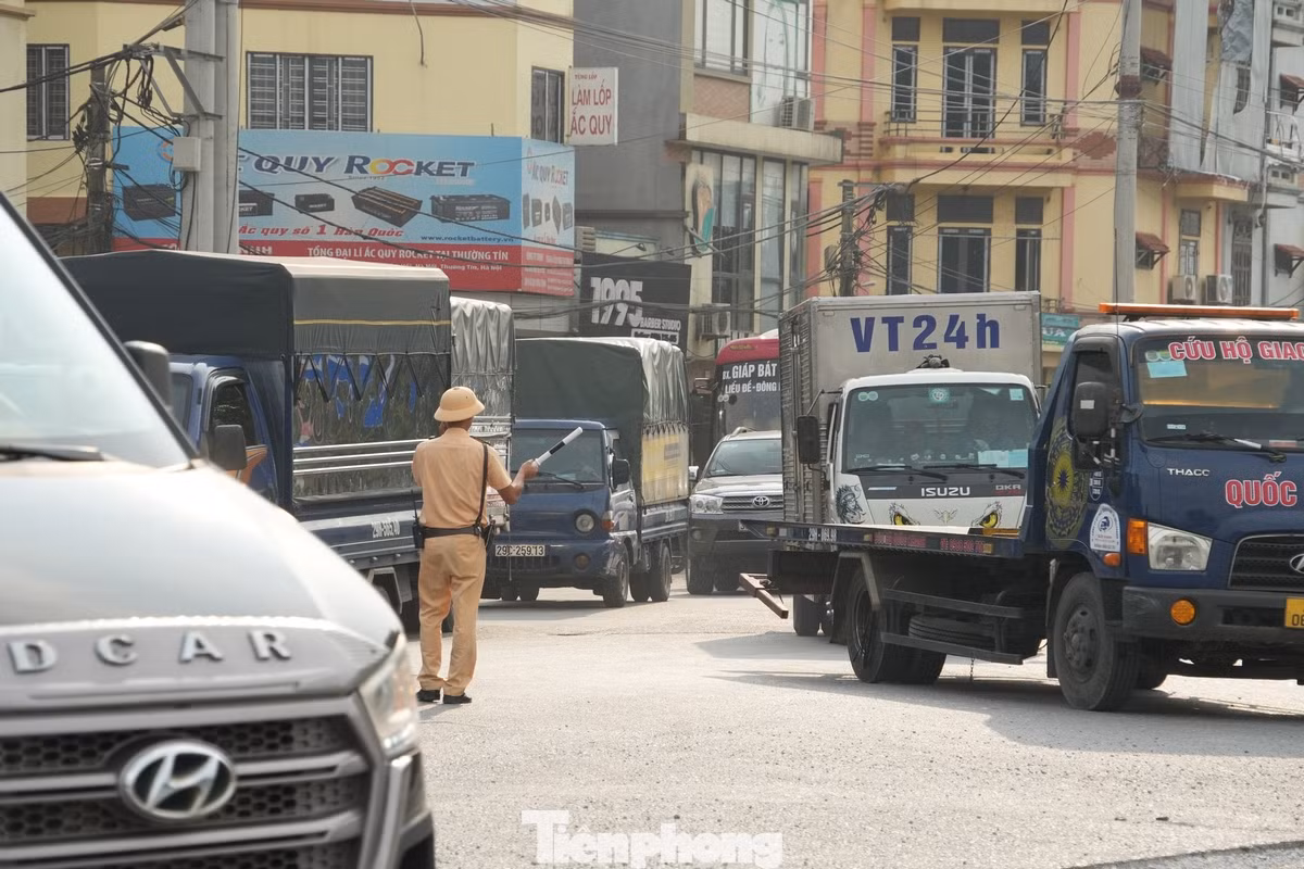 Lực lượng công an vất vả phân luồng các phương tiện đi lên cầu vượt đoạn qua thị trấn Thường Tín.