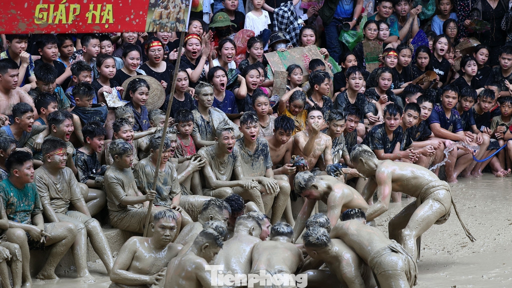 Với kinh nghiệm nhiều năm xem hội, hàng trăm người dân địa phương và du khách đến từ sớm để "xí chỗ" ngồi sát mặt sân thi đấu, chuẩn bị sẵn nhiều dụng cụ chắn bùn như áo mưa, mũ, nón, bìa cát-tông...