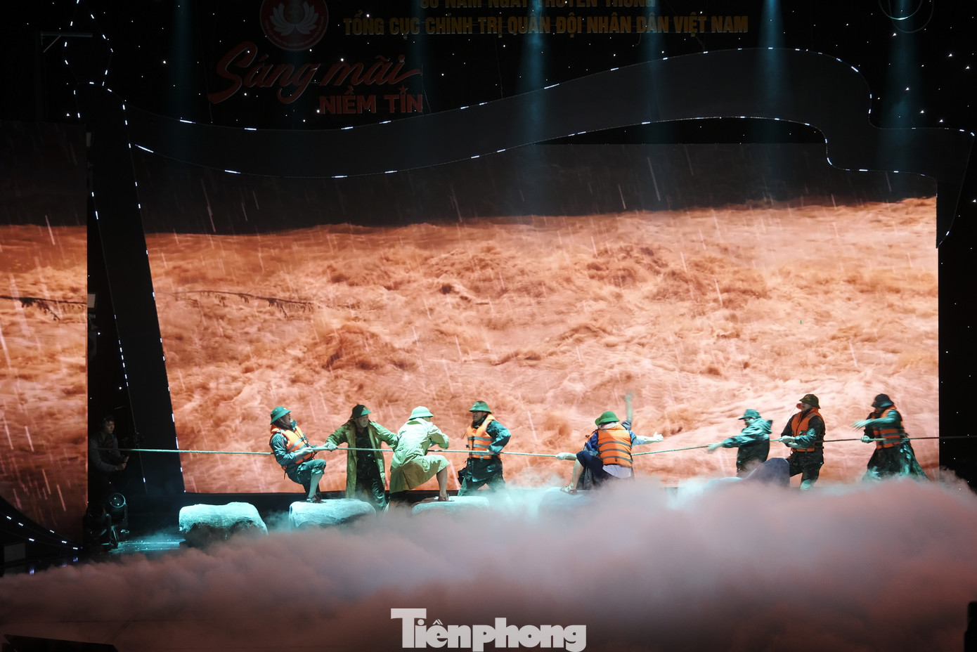 Kịch "Lửa hồng sáng mãi trong mưa" tái hiện lại hoạt cảnh đoàn công tác nhận được cuộc điện thoại thông báo ở thủy điện Rào Trăng 3 có công nhân gặp nạn, ngay sau đó Thiếu tướng Nguyễn Văn Man cùng đồng đội đã quyết định vượt nước lũ để đến với thủy điện Rào Trăng 3 nhưng... đã hy sinh. Ảnh: Châu Linh