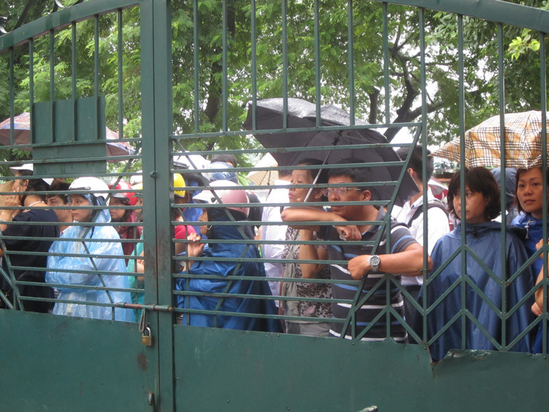 Nhiều phụ huynh đợi con trong mưa ngoài cổng trường