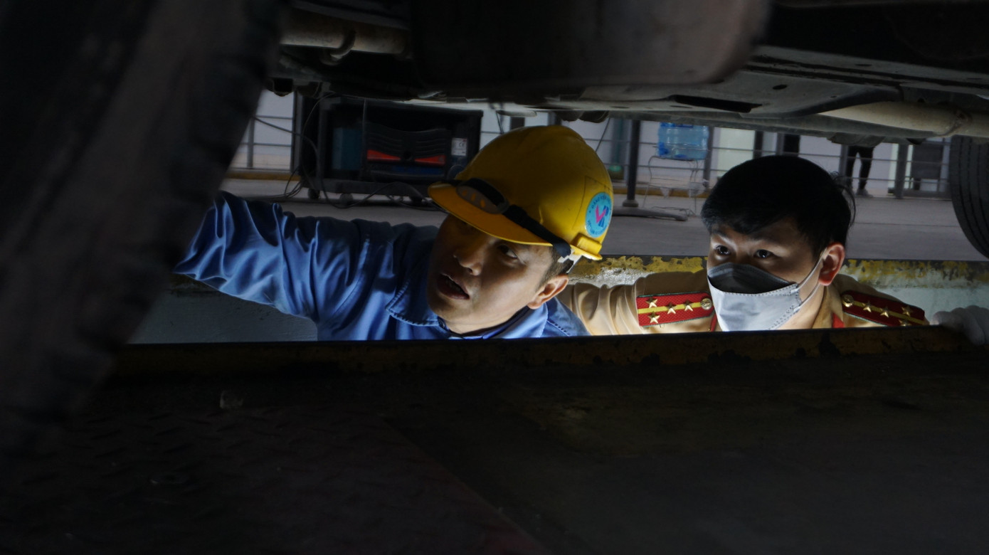 Đại uý Tuấn và đăng kiểm viên hỗ trợ, hướng dẫn kiểm tra hệ thống gầm xe. Đại uý Tuấn và đăng kiểm viên hỗ trợ, hướng dẫn kiểm tra hệ thống gầm xe.