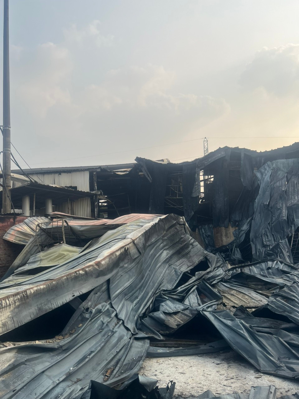 Mái tôn bị biến dạng sau vụ cháy.