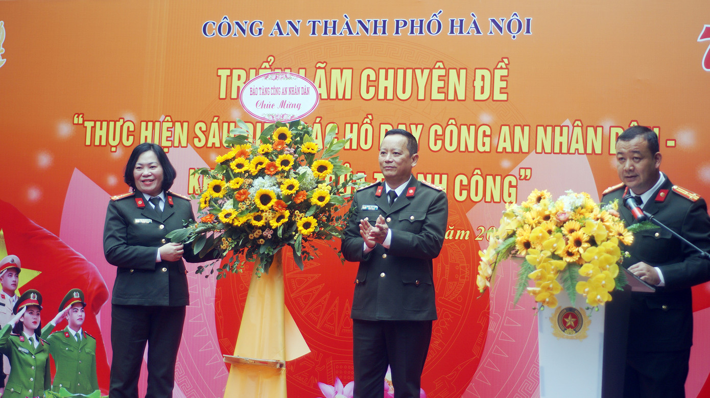 Đại diện Bảo tàng Công an nhân dân tặng lẵng hoa chúc mừng triển lãm.