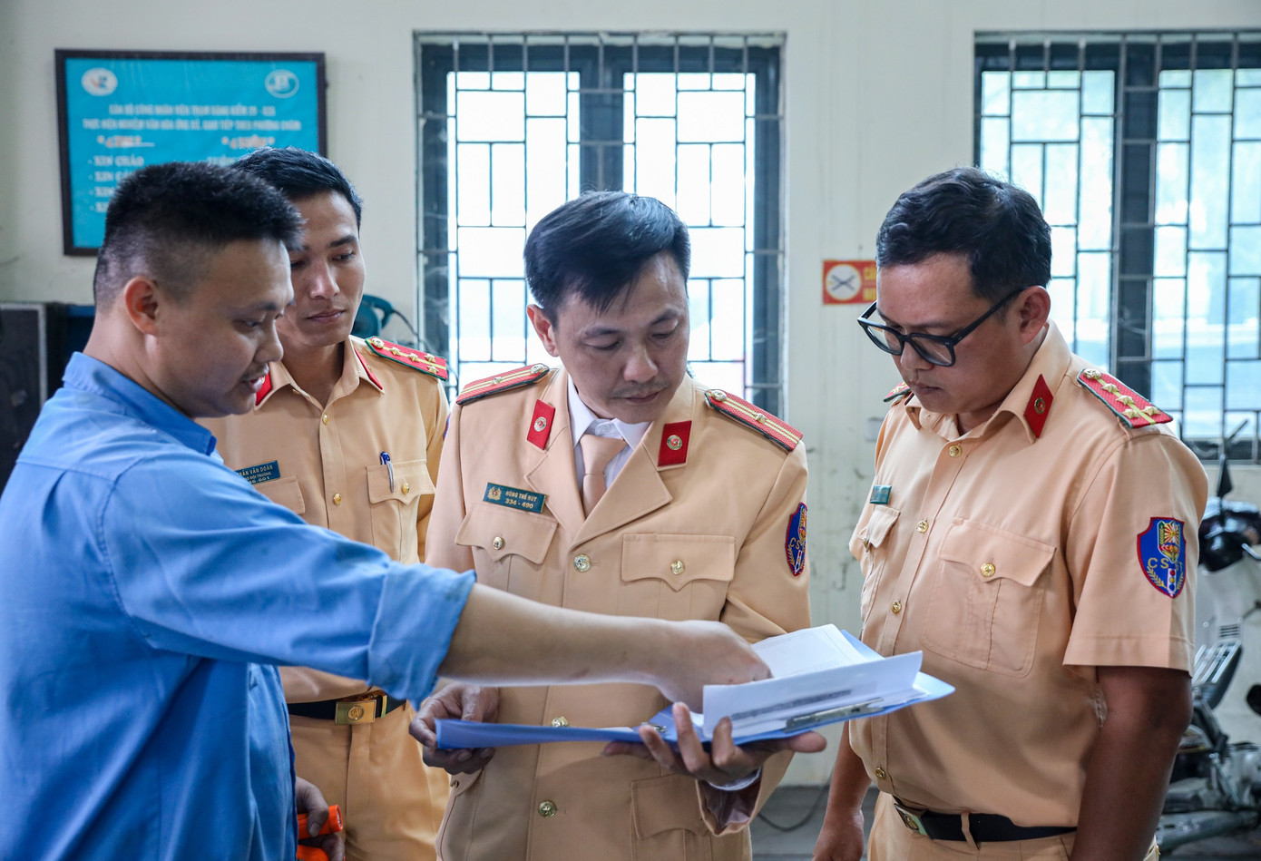 Cán bộ đăng kiểm trao đổi với cán bộ, chiến sĩ CSGT trong khi làm nhiệm vụ.