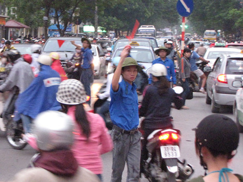 5 giờ chiều 4 - 10, trời đổ mưa và rét, nhưng các sinh viên tình nguyện Học viện Ngân hàng vẫn tham gia điều tiết giao thông trước cổng trường trên phố Chùa Bộc. Ảnh: Lãng Phong.