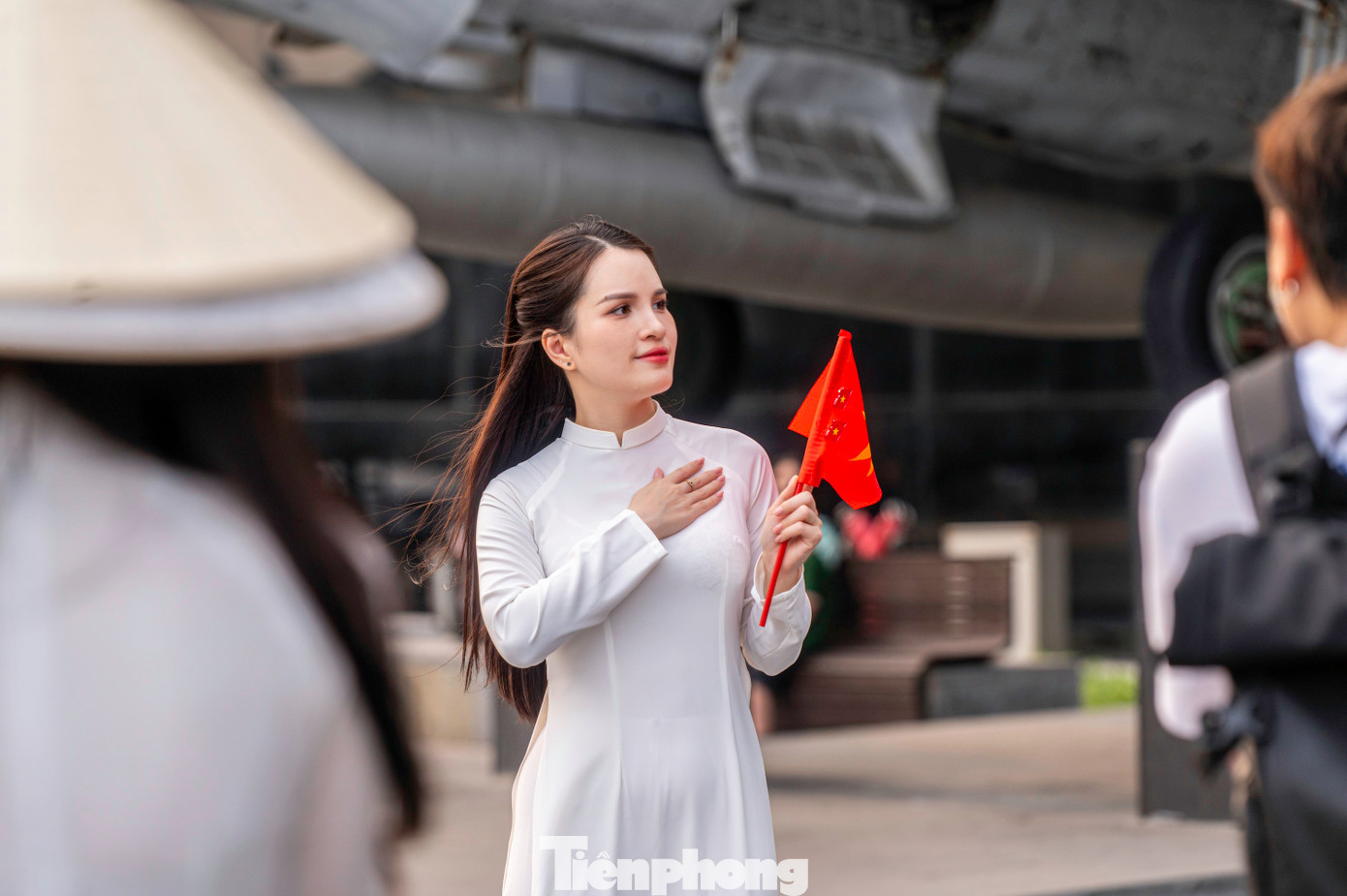 Nhiều du khách mặc áo dài chụp ảnh cùng lá cờ Tổ quốc bay phấp phới trên tay.