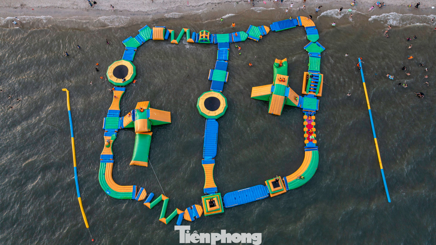 Trẻ em thỏa thích nô đùa bên nhà phao và xây lâu đài cát ngay bên cạnh bờ biển.