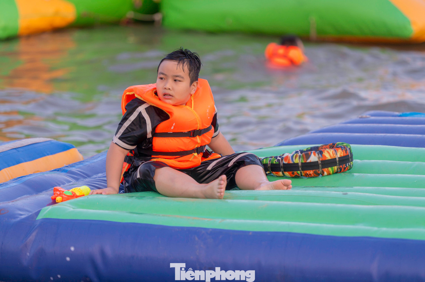 Trẻ em thỏa thích nô đùa bên nhà phao và xây lâu đài cát ngay bên cạnh bờ biển.