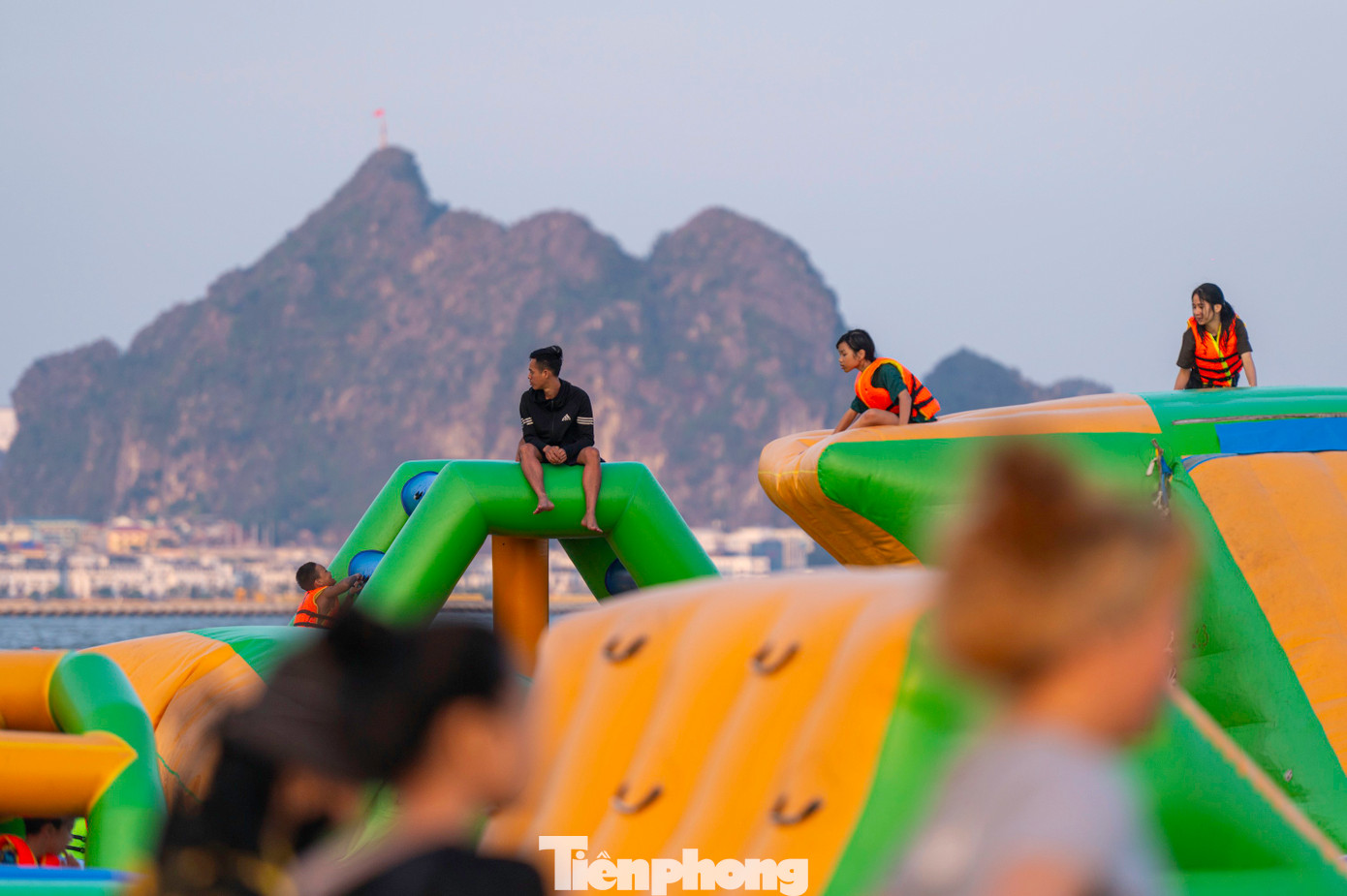 Trẻ em thỏa thích nô đùa bên nhà phao và xây lâu đài cát ngay bên cạnh bờ biển.