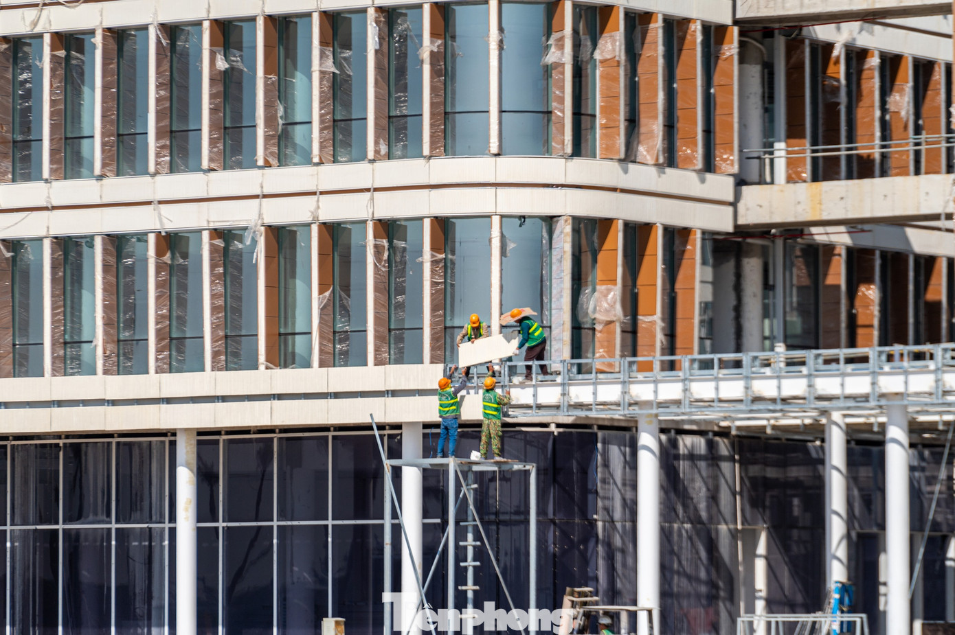 Các công nhân đang hoàn thiện trang trí bên ngoài phía tòa nhà.