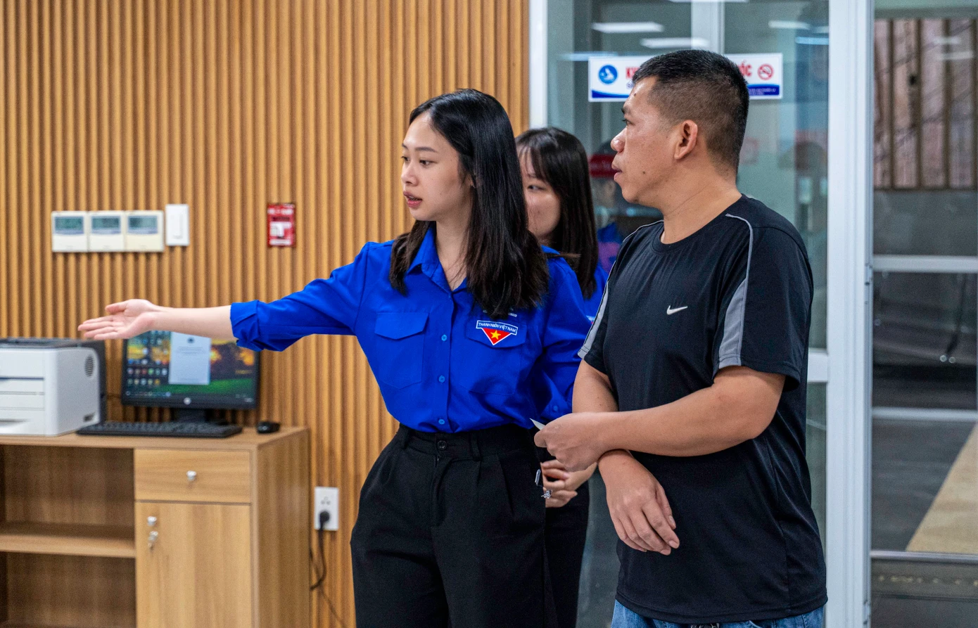 Lực lượng đoàn viên, thanh niên hướng dẫn người dân lấy số và vào các quầy tương ứng để làm thủ tục.