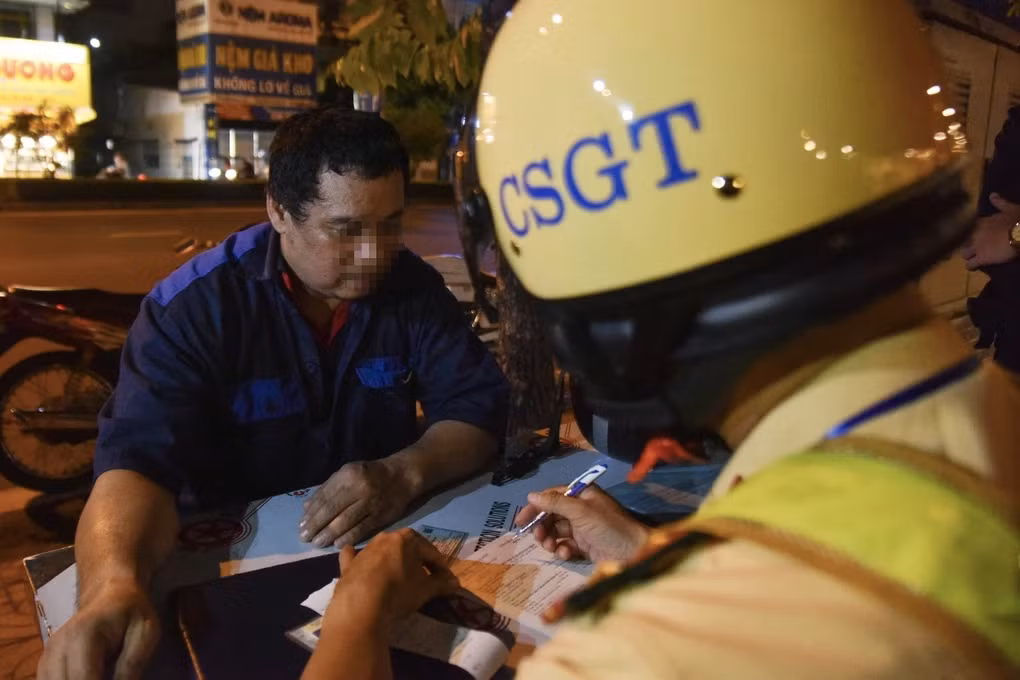Khi biết không thể nhờ người can thiệp CSGT, tài xế T. mới chịu ngồi vào bàn ký biên bản (Ảnh: Trịnh Nguyễn).