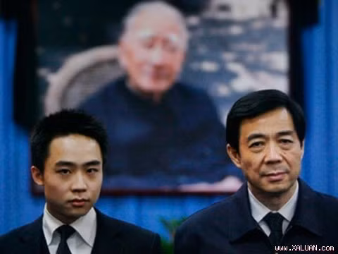 Bạc Hy Lai và con trai Bạc Qua Qua phía sau là bức ảnh người cha Bạc Nhất Ba, một lão thành cách mạng của Đảng cộng sản Trung Quốc