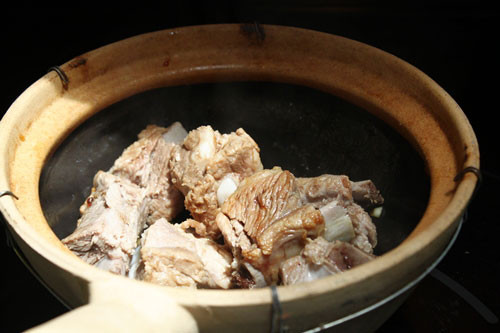 Cho sườn vào niêu cùng gia vị, đảo đều