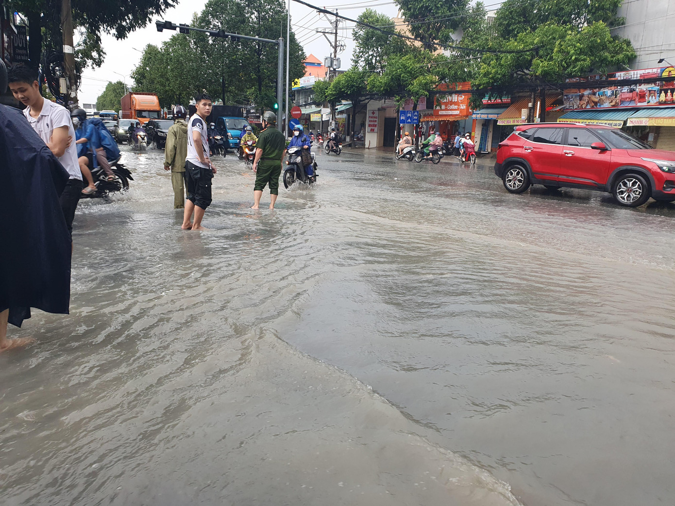 Lực lượng chức năng điều tiết giao thông qua đoạn đường bị ngập nước