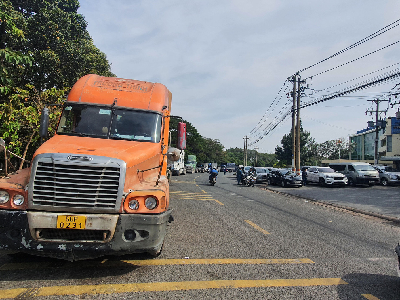 Xe xếp hàng dài bên đường chờ nhận phiếu vào kiểm định