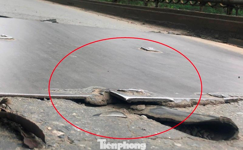 Do lưu lượng phương tiện đông, liên tục chèn lên dẫn đến tấm sắt bị võng xuống, nhiều đầu đinh nhọn nhô lên khỏi mặt cầu (vòng tròn) rất nguy hiểm với người, phương tiện lưu thông. Ảnh chụp sáng 7/4 tại chiều cầu theo hướng Hà Nội - Long Biên.