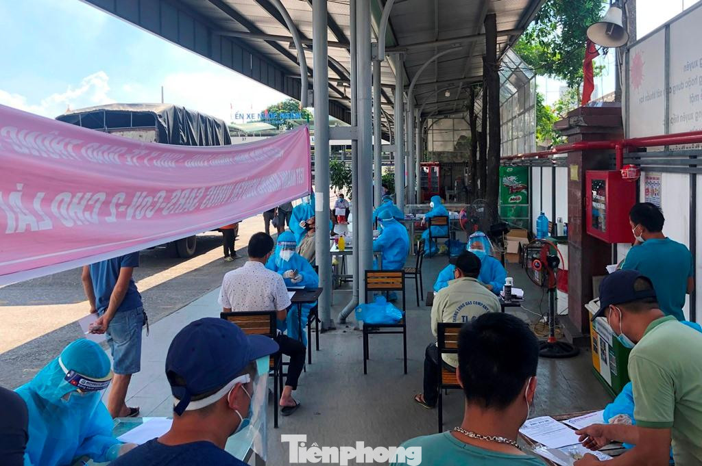 Lái xe và người dân ngồi xếp hàng chờ được đến lượt làm xét nghiệm.