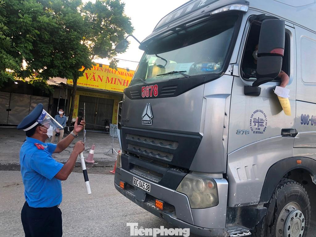 Ghi nhận thực tế trên, trong ngày hôm qua PV Tiền Phong đã đi khảo sát một số chốt kiểm soát cửa ngõ. Trong ảnh: Thanh tra giao thông tại chốt Cầu Giẽ (huyện Phú Xuyên) dừng kiểm mã luồng xanh xe tải 90C-04538 chở hàng chạy hướng Hà Nội - Hà Nam.