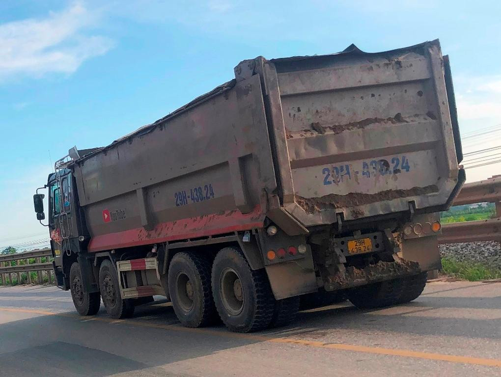 Nhiều xe chạy ra đường không được phun rửa, che chắn kỹ theo quy định, để phế thải rơi vãi ra đường.