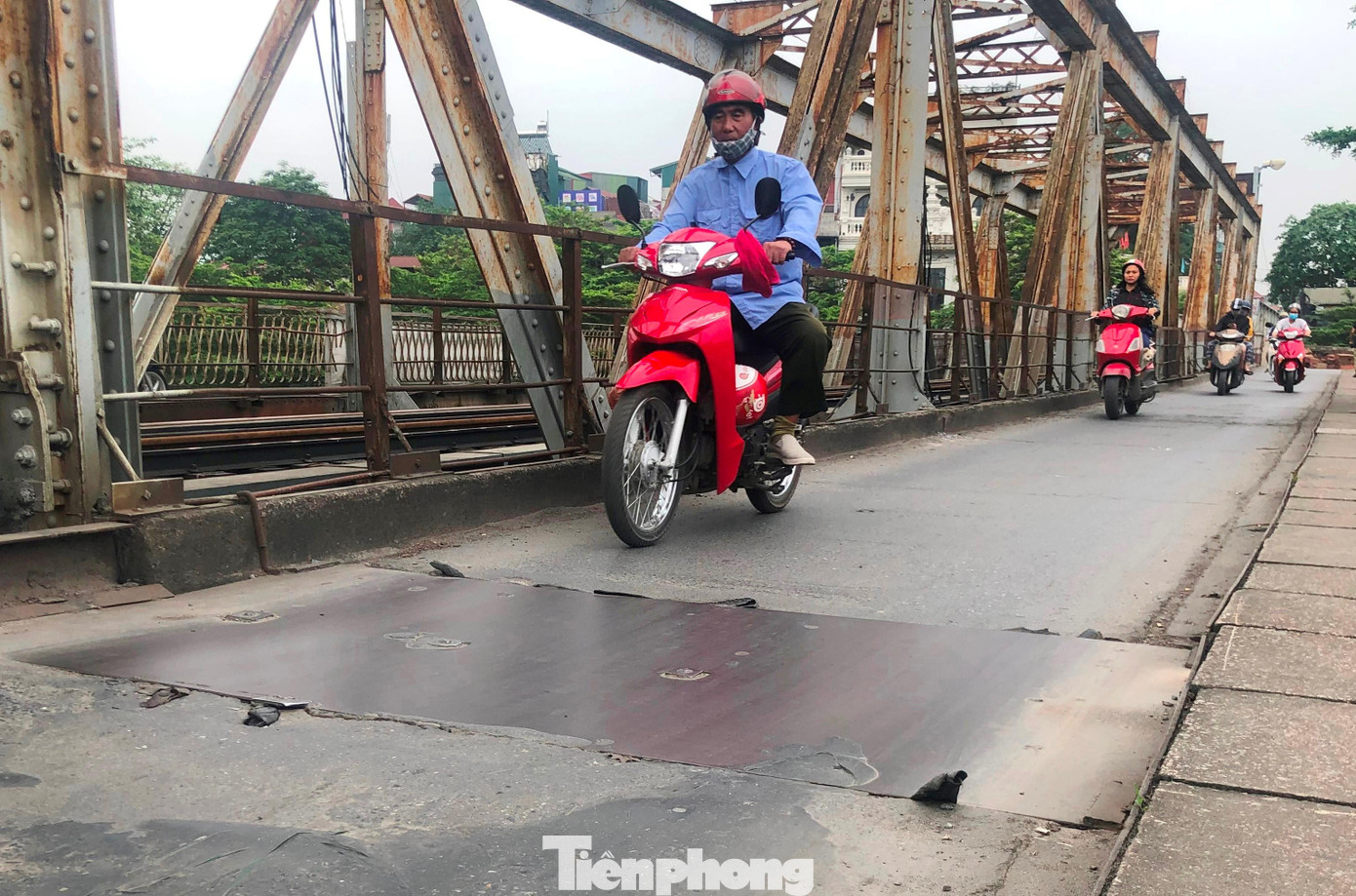 Sáng 7/4, PV Tiền Phong ghi nhận còn nhiều đoạn bị nứt thủng chưa được trải thảm lại, đơn vị quản lý cầu đã dùng tạm các tấm thép đậy lại để phương tiện đi qua.