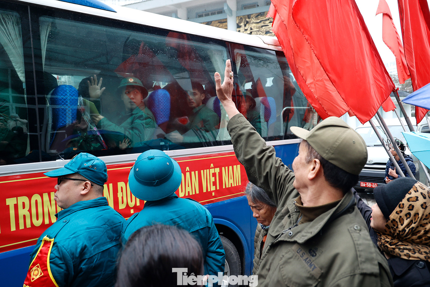 Người thân vẫy tay chào các tân binh lên đường nhập ngũ vào sáng 26/2.
