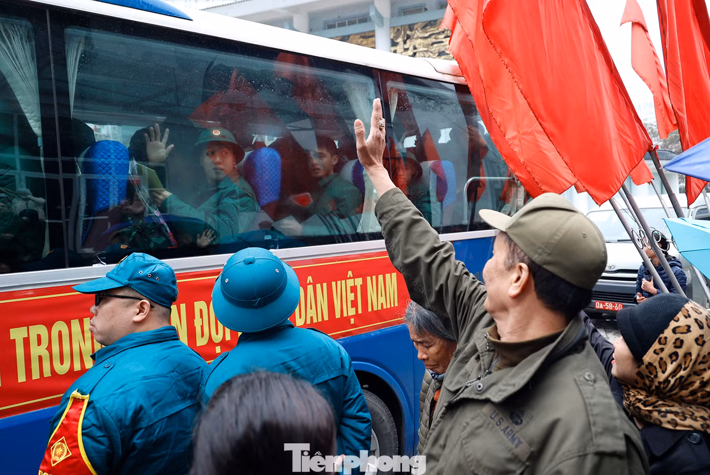 Người thân vẫy tay chào các tân binh lên đường nhập ngũ vào sáng 26/2.