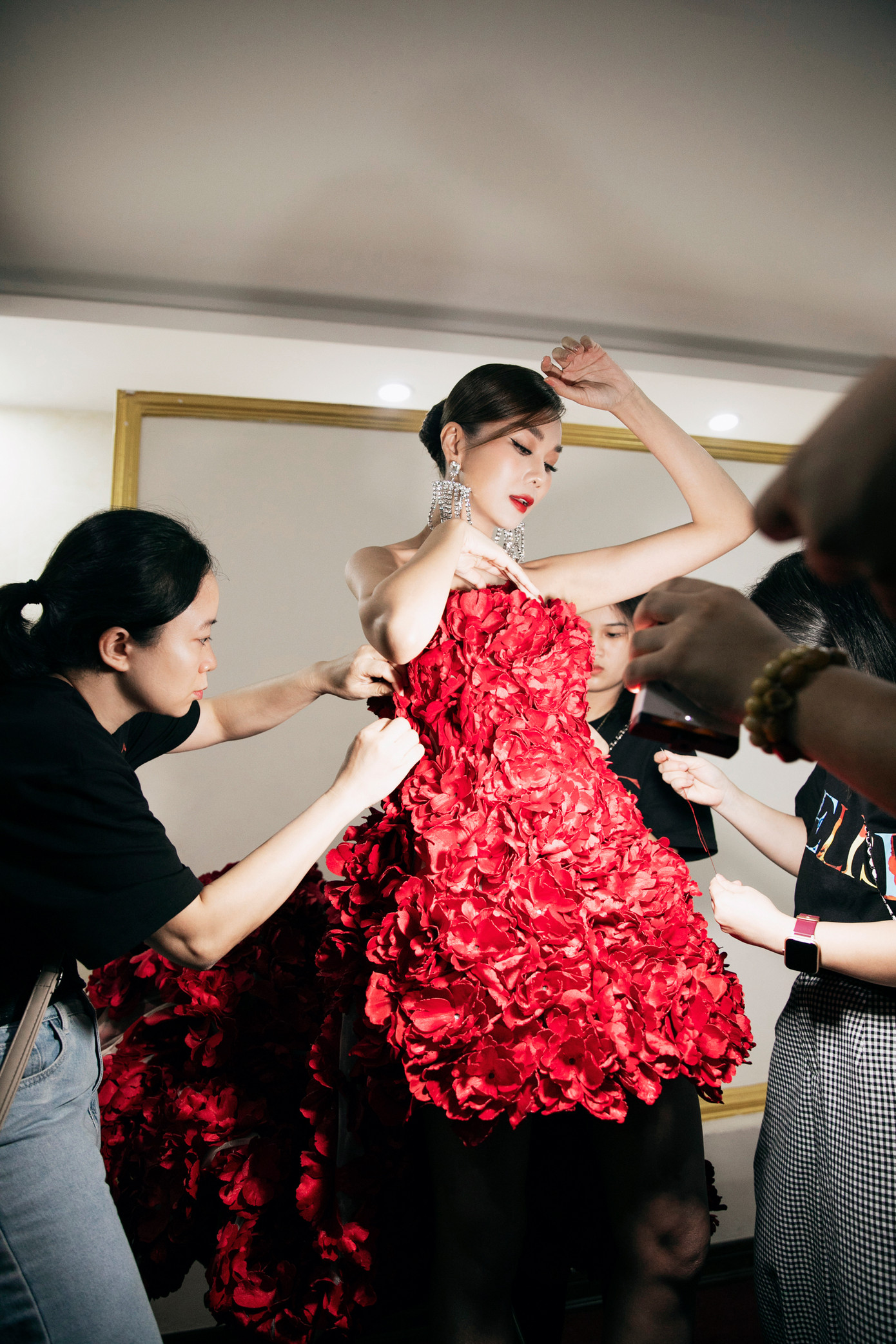 Người mẫu Thanh Hằng đảm nhận vai trò vedette trong sự kiện. Cô chật vật trong hậu trường khi mặc bộ váy nặng 20 kg khi đính 1.000 hoa lụa thủ công trên khung corset kim loại.