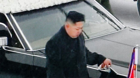 Đại tướng Kim Jong Un trong bộ đồ đen đi bên linh cữu cha. Ảnh: AP