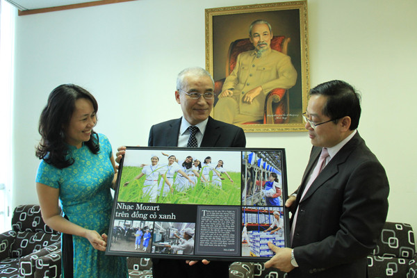 Tổng Biên tập Lê Xuân Sơn (bìa phải) tặng tác phẩm của phóng viên Tiền phong cho đại diện tập đoàn TH. Ảnh: Trường Phong