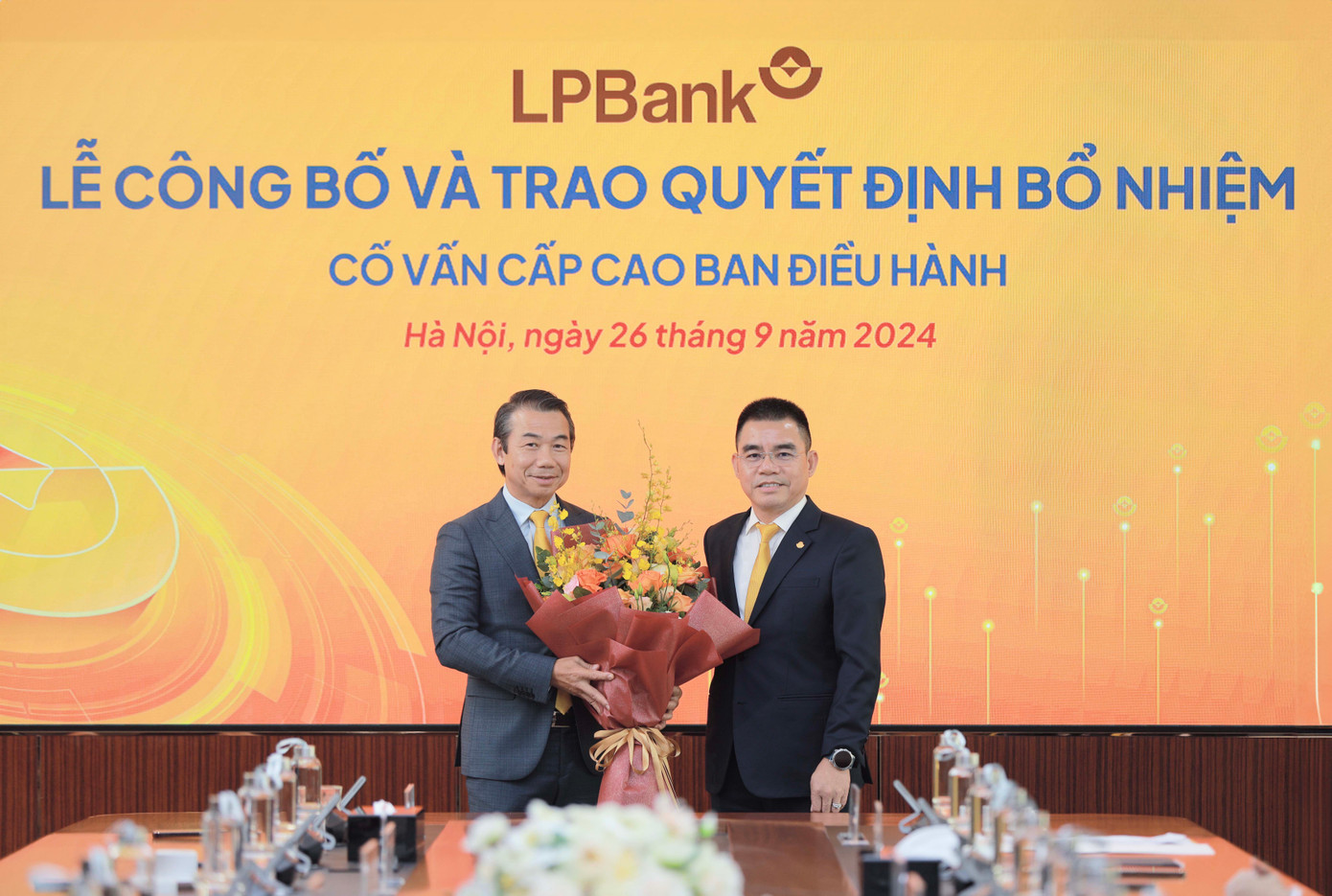 Ông Hồ Nam Tiến – Phó Chủ tịch HĐQT kiêm Tổng Giám đốc LPBank (phải) trao hoa chúc mừng ông Phạm Phú Khôi (trái)