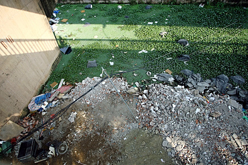  Phế thải xây dựng được đổ bừa bãi xuống chân cầu, lấn sang cả những ao nước tù đọng bên cạnh