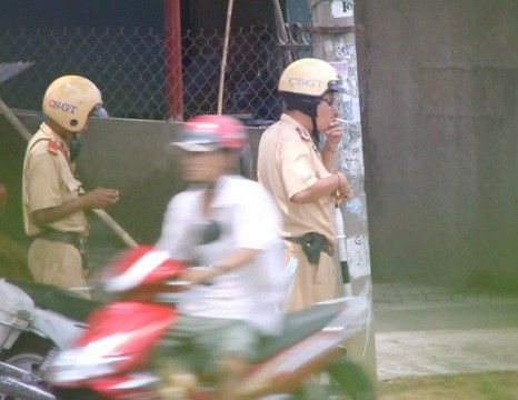 CSGT Q.9 vừa hút thuốc, vừa đeo kính đen khi đang làm nhiệm vụ (ảnh: N.D) 