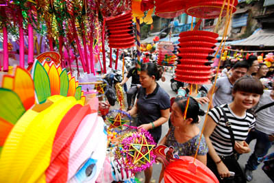 Người lớn và thanh niên cùng với những sắc màu của những lồng đèn giấy. Người lớn và thanh niên cùng với những sắc màu của những lồng đèn giấy