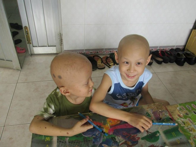 Minh Khang và Anh Dũng đang chờ các anh chị tình nguyện lấy vở để tập viết