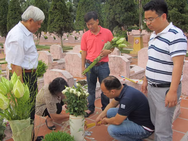 TS Nguyễn Huy Hoàng (đầu bạc) cùng anh em CLB May Thăng Long viếng mộ chị Đặng Thùy Trâm