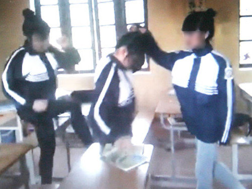 Hai nữ sinh thi nhau đạp và tát bạn ngay trong lớp học. Ảnh: chụp từ clip Hai nữ sinh thi nhau đạp và tát bạn ngay trong lớp học