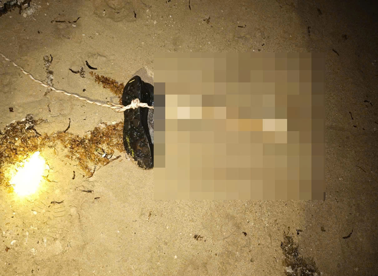 Đoạn xương chân còn mang giầy được người dân đưa lên bờ