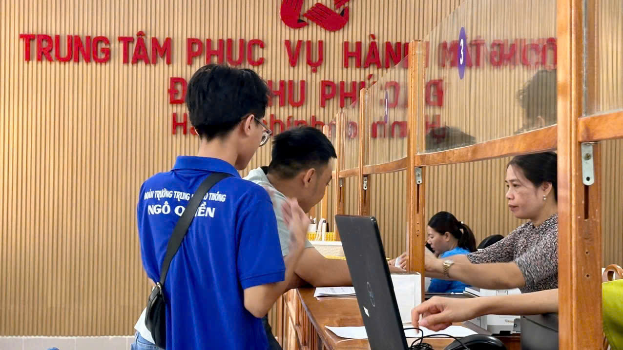 Đoàn viên Quốc Bình đang giúp người dân đăng ký giấy tờ đất, giấy phép kinh doanh, giấy khai sinh và kí xác nhận một số giấy tờ khác.