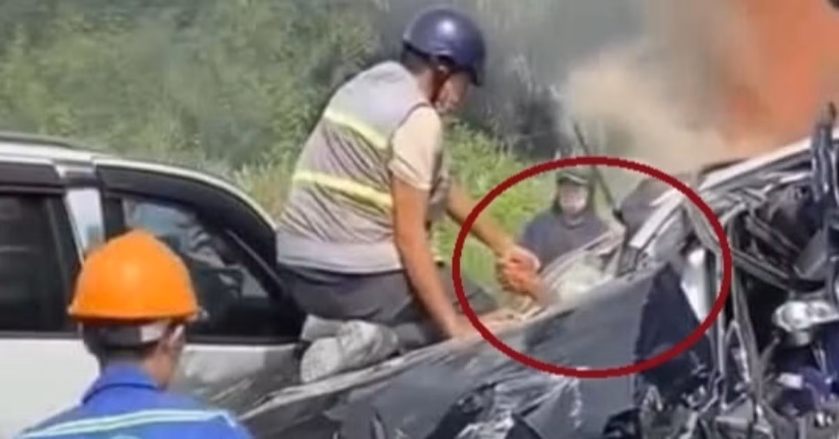 Hình ảnh anh Duy Quang kéo tài xế kẹt trong xe Volvo thoát ra ngoài. Ảnh cắt từ clip.
