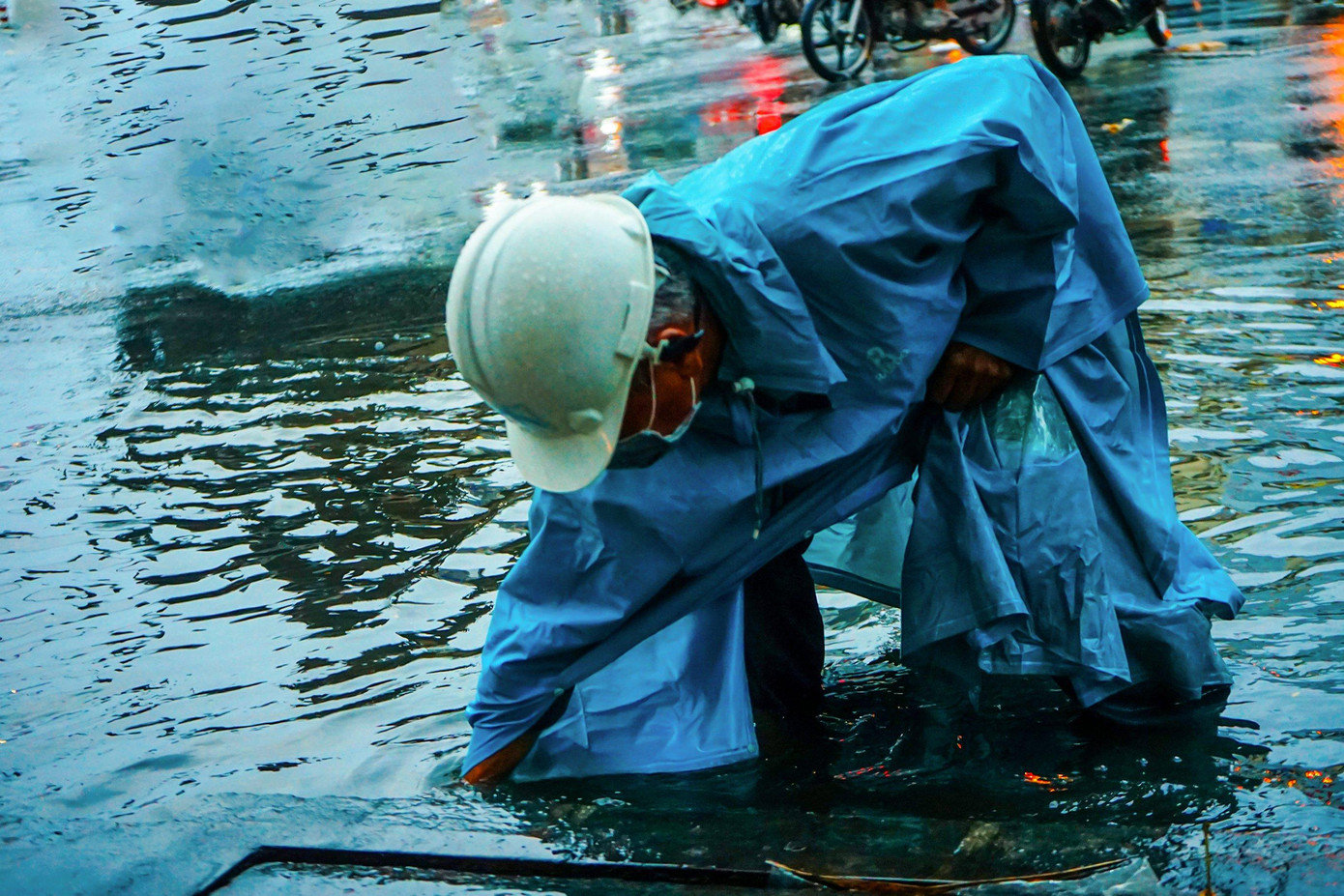 Nhân viên Công ty thoát nước đô thị TPHCM dùng tay khơi thông cống ở giao lộ đường Calmetter và Nguyễn Thái Bình, quận 1.