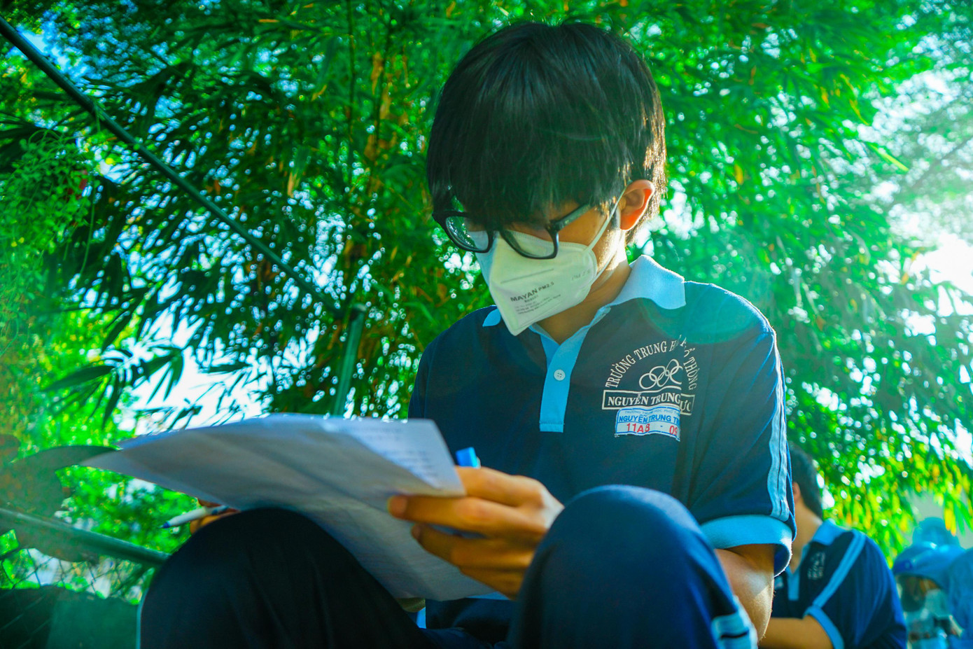 Học sinh trường THPT Nguyễn Trung Trực kiểm tra và ký giấy xác nhận trước khi vào khu vực khám sàng lọc trước khi tiêm.