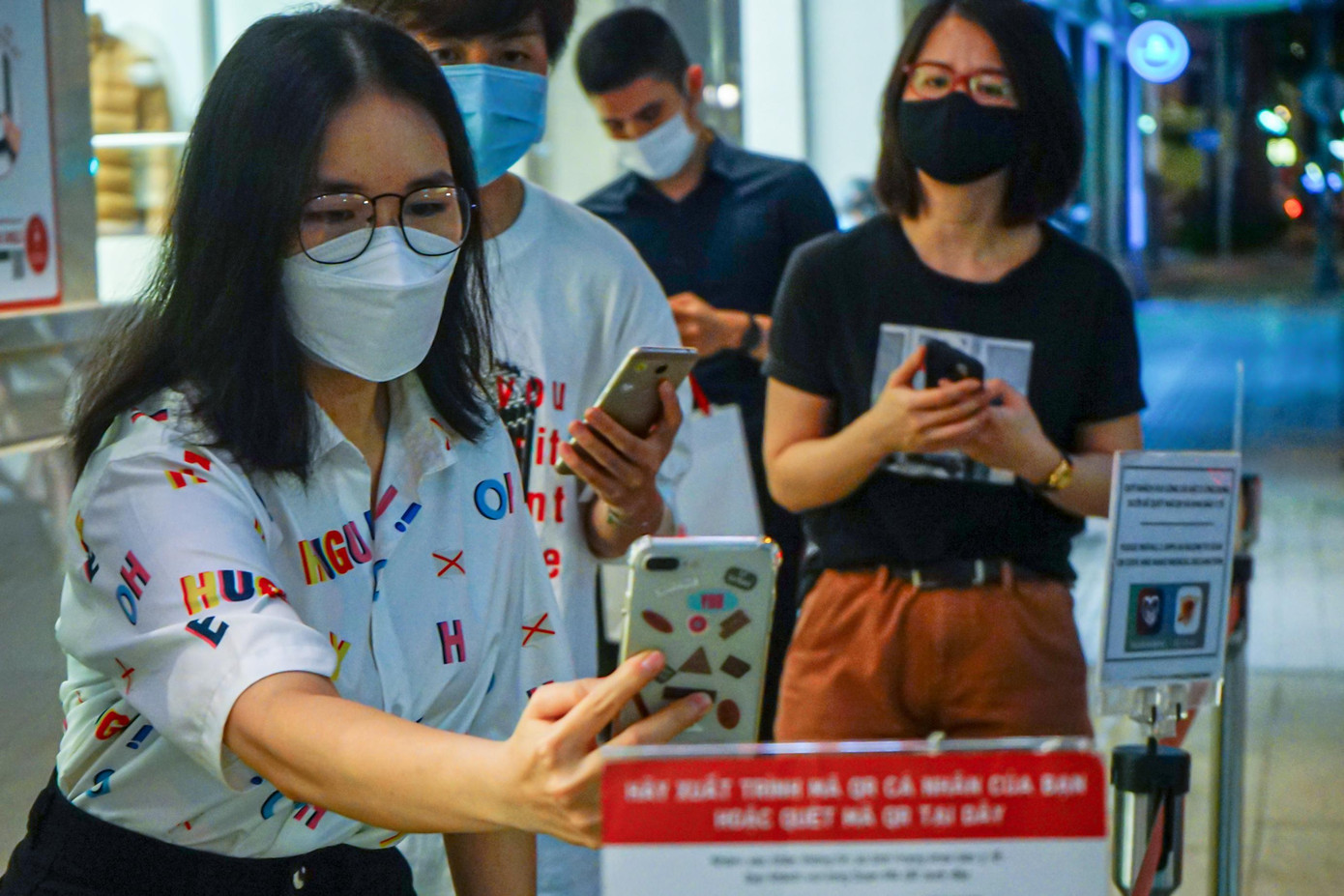 Khách hàng quét mã QR khai báo y tế trước khi vào cửa hàng mua sắm.