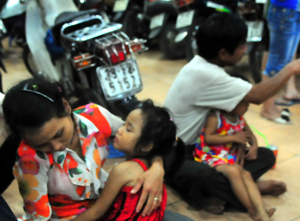 Một số gia đình phải đưa trẻ em vào khu gửi xe của siêu thị Thiên Sơn để lánh nạn tắc đường.