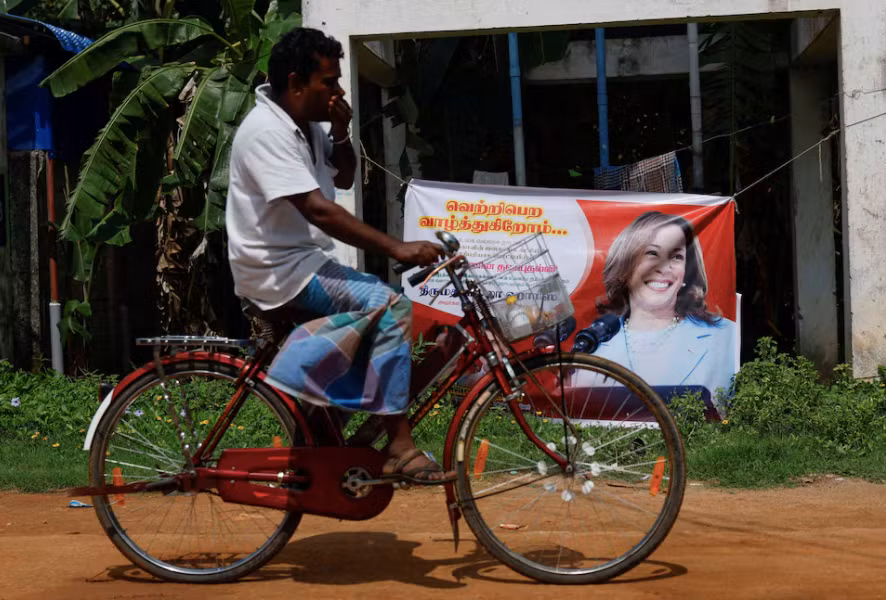Một người đàn ông đạp xe ngang qua tấm áp phích in chân dung Phó Tổng thống Mỹ Kamala Harris tại Thulasendrapuram, nơi sinh của ông ngoại bà Harris, ngày 4/11. (Ảnh: Reuters)