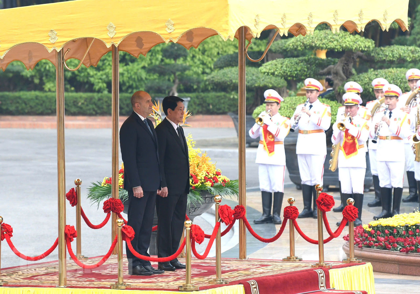 Chủ tịch nước Lương Cường và Tổng thống Bulgaria Rumen Radev đứng trên bục danh dự trong lúc đội quân nhạc cử hành quốc thiều hai nước. (Ảnh: Như Ý)