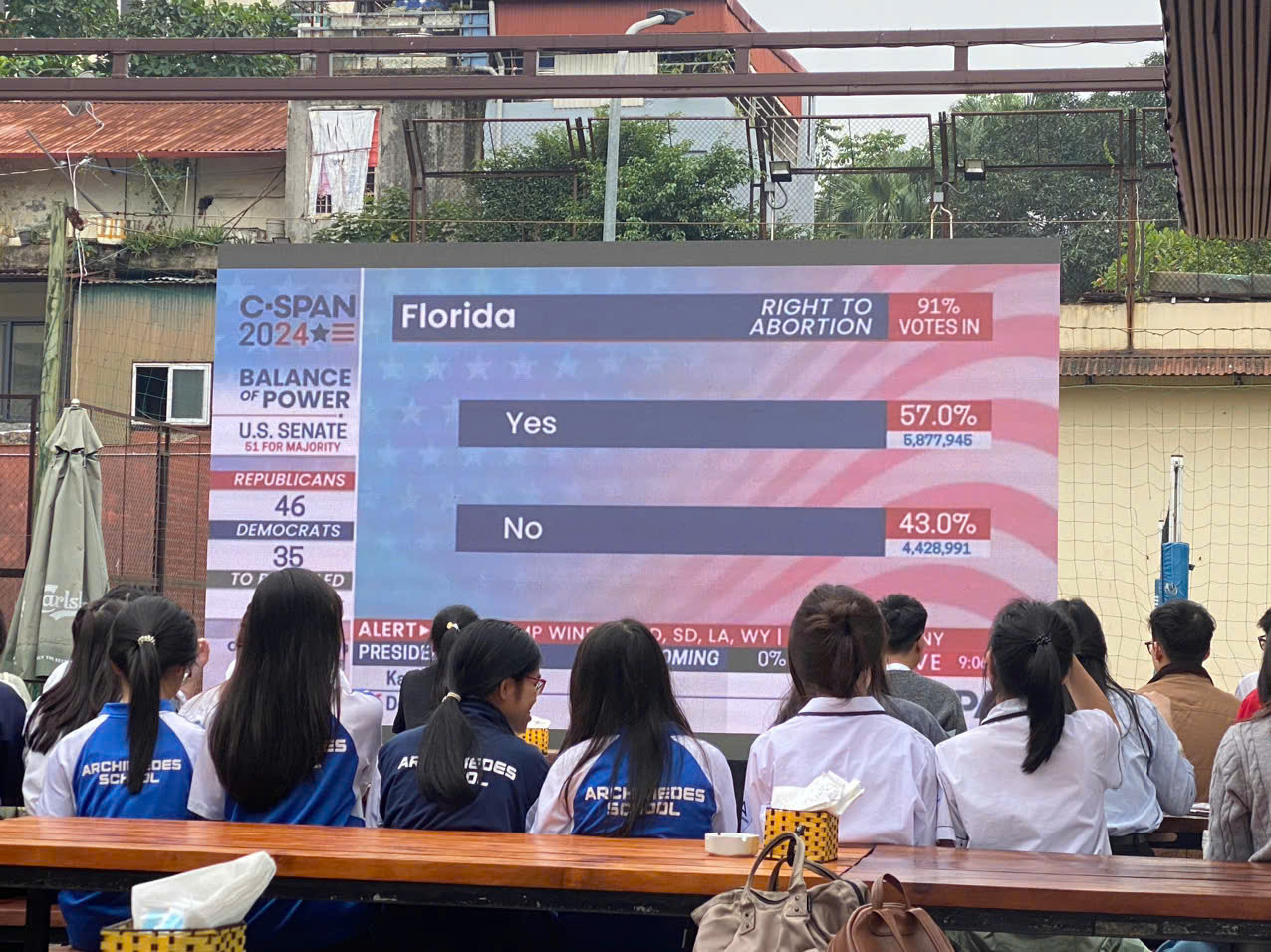 Các bạn học sinh và sinh viên theo dõi màn hình tường thuật trực tiếp kết quả kiểm phiếu bầu cử Mỹ. (Ảnh: Thu Loan)