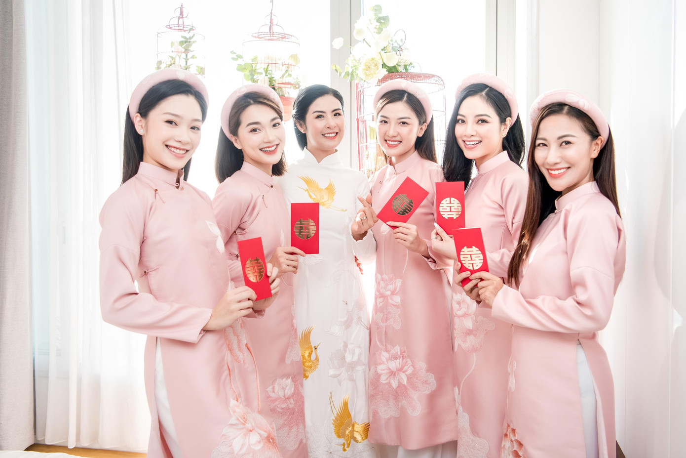 Dàn bê tráp của Ngọc Hân diện áo dài khăn đóng tông màu hồng pastel nữ tính, ngọt ngào. Các người đẹp cũng chọn phong cách trang điểm dịu dàng, thanh lịch để phù hợp buổi lễ.