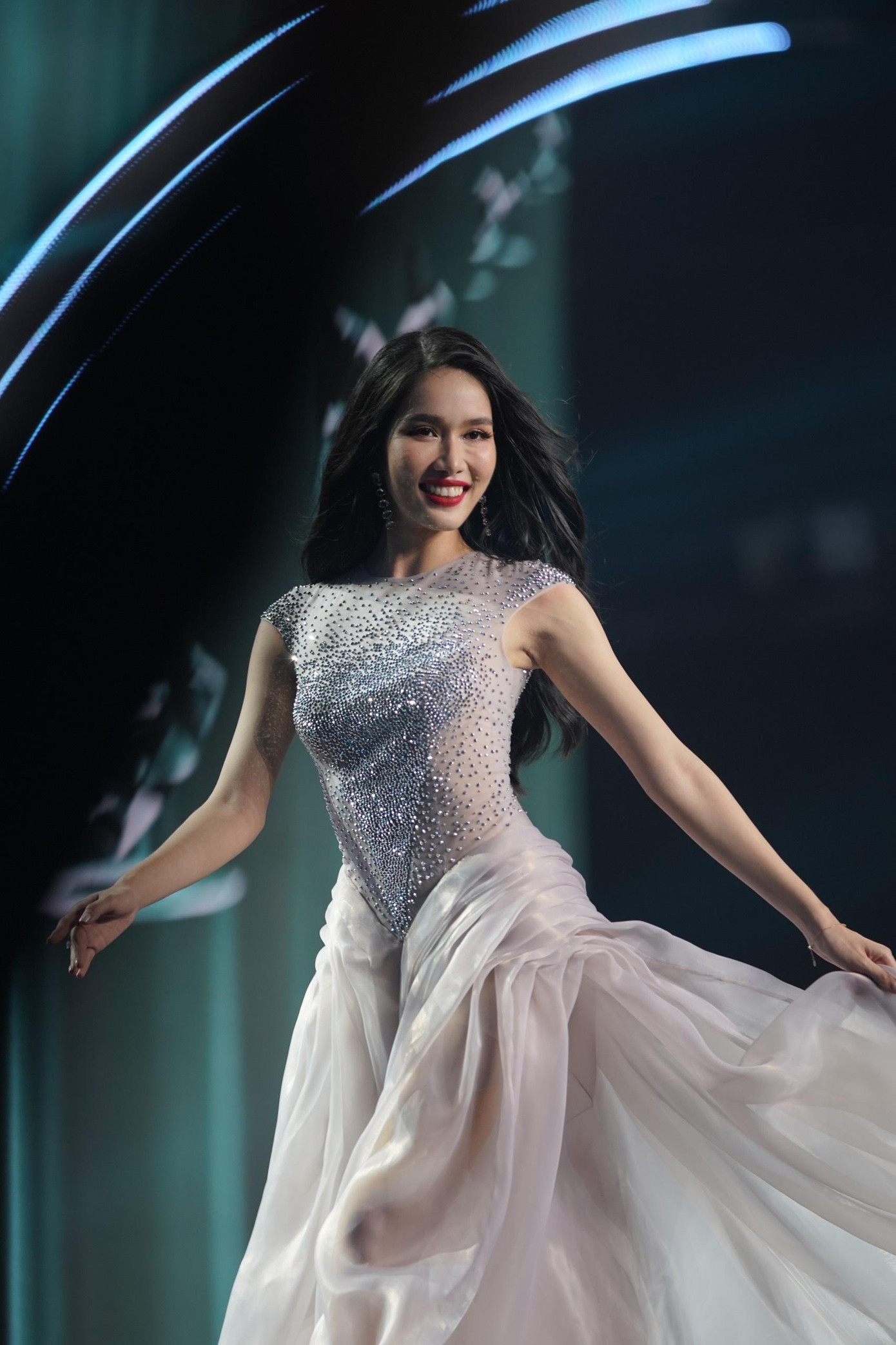 Á hậu Phương Anh đảm nhận vai trò first face của màn trình diễn. Cô diện bộ váy màu bạc được đính kết cầu kỳ, lấp lánh.